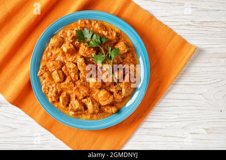 mungh makhani, pollo al burro, curry di pollo tandoori in un pomodoro speziato e salsa di panna su un piatto su un tavolo, cucina indiana, vista orizzontale fro Foto Stock