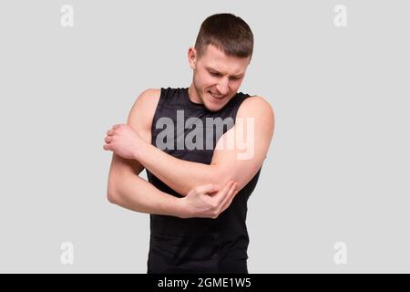 Sport uomo che tiene gomito. Uomo che ha lesioni. Sport uomo infortunio gomito Foto Stock