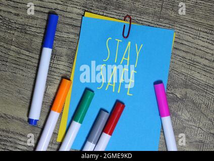 Vista dall'alto del notepaper a colori circondato da penna colorata con testo, MASSIMA SICUREZZA. Foto Stock