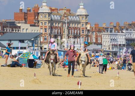 Weymouth, Dorset, Regno Unito. 18 settembre 2021. Meteo Regno Unito. I bambini potranno godersi un giro in asino sulla spiaggia, nel caldo sole autunnale della località balneare di Weymouth, nel Dorset. Picture Credit: Graham Hunt/Alamy Live News Foto Stock