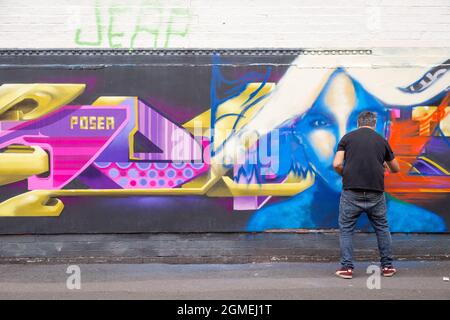 Birmingham, Regno Unito. 18 settembre 2021. Un artista graffiti al lavoro durante l'High Vis Street Culture Festival che si svolge nel corso del fine settimana a Digbeth, Birmingham. Il quartiere di Digbeth della città è conosciuto per la sua cultura dei graffiti di strada. Credit: Peter Lopeman/Alamy Live News Foto Stock