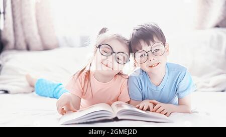 I bambini si trovano sul letto accanto al neonato, sorellina. Emozioni dei bambini. Foto Stock