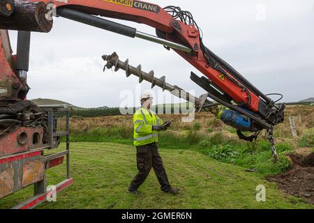 Installazione di un palo per un cavo a banda larga in fibra ottica Foto Stock