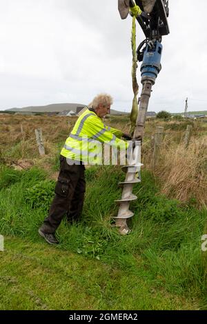 Installazione di un palo per un cavo a banda larga in fibra ottica Foto Stock