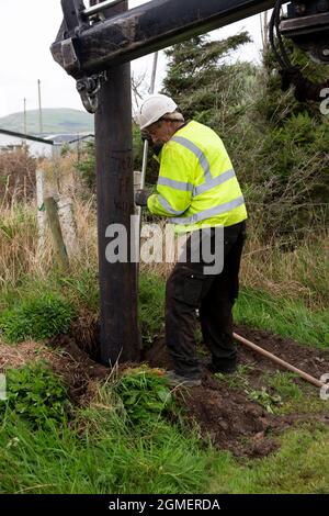 Installazione di un palo per un cavo a banda larga in fibra ottica Foto Stock