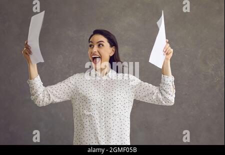 Entusiasta ragazza casual imprenditore lettura buone notizie in studio di lettera sparato Foto Stock