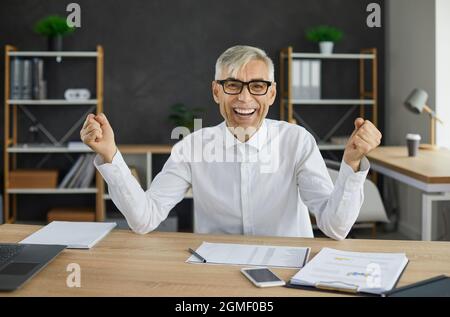 Ritratto di un eccitatissimo uomo d'affari emozionale anziano che gioisce nel suo successo. Foto Stock