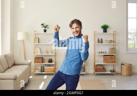 Felice giovane gioisce che è diventato proprietario del suo nuovo appartamento. Foto Stock