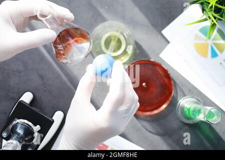 Ricerca di laboratorio. Analisi dei farmaci. Esperimenti chimici in laboratorio. Microscopio varie provette e becher sul tavolo presso il medico ufficiale. Foto Stock