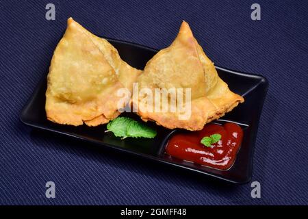 Samosa con salsa in piatto, famoso cibo asiatico ripieni Samosa Foto Stock