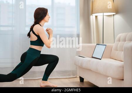 La giovane donna è impegnata in yoga remoto o stretching. Foto Stock