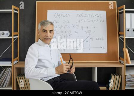 Insegnante di mezza età che dà lezioni online, concetto di formazione online. Foto Stock