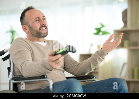 felice uomo disabile che gioca giochi al computer durante la riabilitazione Foto Stock