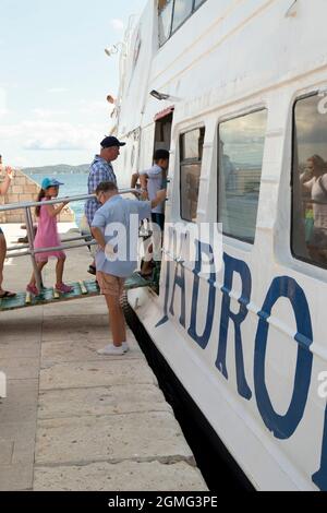 Vodice, Croazia - 25 agosto 2021: Persone che si imbarcaranno su una nave Jadrolinija da un molo Foto Stock