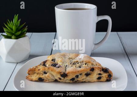 tazza di caffè servita con un cono di mirtilli Foto Stock