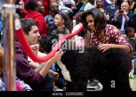 First Lady Michelle Obama e Bo, il cane della famiglia Obama, salutano i membri del pubblico presso il Children’s National Medical Center di Washington, D.C., 12 dicembre 2011. La signora Obama ha letto 'Twas the Night Before Christmas' durante un programma di vacanze natalizie con bambini, genitori e personale. (Foto ufficiale della Casa Bianca di Chuck Kennedy) questa fotografia ufficiale della Casa Bianca è resa disponibile solo per la pubblicazione da parte delle organizzazioni di notizie e/o per uso personale la stampa dal soggetto(i) della fotografia. La fotografia non può essere manipolata in alcun modo e non può essere utilizzata in materiali commerciali o politici, a Foto Stock