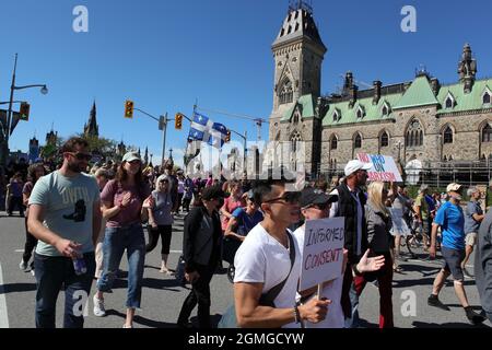 Persone contro la vaccinazione obbligatoria, la coercizione e l'attuazione dei passaporti di vaccinazione che marciano dalla collina del Parlamento a Ottawa, Cap Nazionale Foto Stock