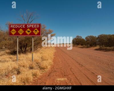 Ridurre la velocità Condizioni di guida pericolose segnale di avvertimento stradale su Mereenie Loop Road, Northern Territory. Foto Stock