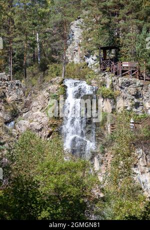 Primo piano di una potente cascata di alta qualità. Vista laterale di una cascata soleggiato nella natura selvaggia. Un grande flusso d'acqua si riversa verso il basso dal monte Foto Stock