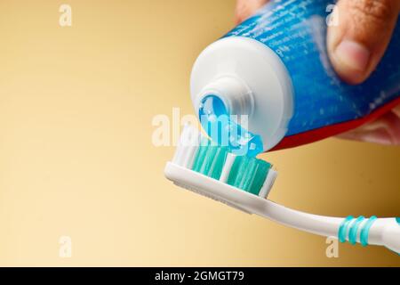 Applicazione del dentifricio sullo spazzolino Foto Stock