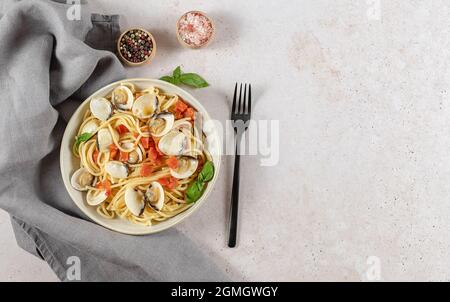 Gustoso appetitoso vongole fresche fatte in casa vongole pasta di pesce con pomodori, aglio e vino bianco sul piatto. Vista dall'alto, spazio copia.