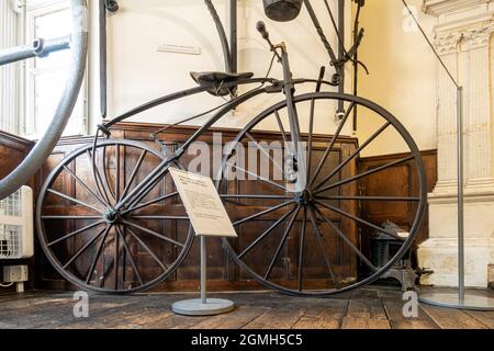 All'interno del Guildford Museum con mostre di storia locale, Surrey, Inghilterra, Regno Unito. Una vecchia bicicletta boneshaker con ruote in legno in mostra. Foto Stock