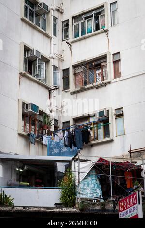 Appartamenti a Yuen Long, New Territories, Hong Kong, con lavanderia asciuga su scaffali fuori finestra Foto Stock