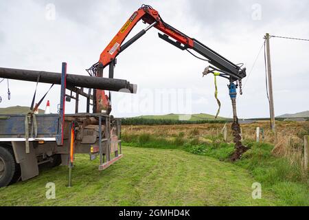 Installazione di un palo per un cavo a banda larga in fibra ottica Foto Stock