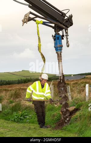 Installazione di un palo per un cavo a banda larga in fibra ottica Foto Stock