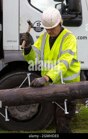 Installazione di un palo per un cavo a banda larga in fibra ottica Foto Stock