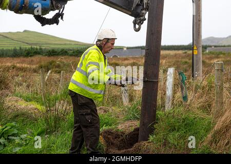 Installazione di un palo per un cavo a banda larga in fibra ottica Foto Stock