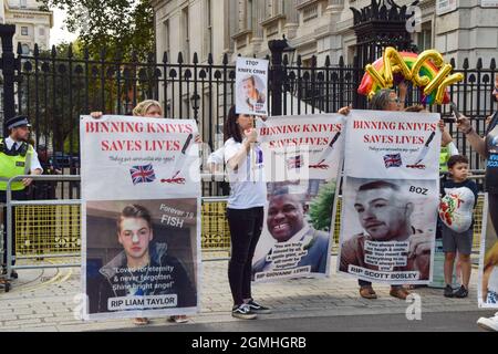 Londra, Regno Unito. 18 settembre 2021. Gli attivisti tengono foto delle vittime del crimine di coltello fuori da Downing Street durante la dimostrazione "Binning Knives Saves Lives". Foto Stock