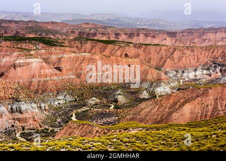 Strada tortuosa tra i colorati Monti Los Colorados, Gorafe, Andalusia, Spagna Foto Stock