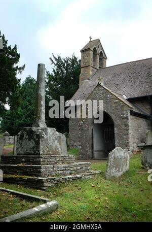 Resti di croce medievale fuori l'ingresso della chiesa di St Mary, Walterstone, Herefordshire, Inghilterra, Regno Unito Foto Stock