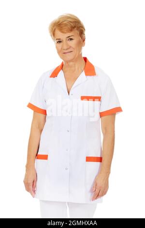 Una dottoressa anziana che indossa una uniforme bianca e arancione isolata su sfondo bianco Foto Stock