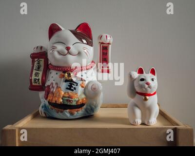 Coppia di gatti di fortuna asiatici su una cassa di legno Foto Stock