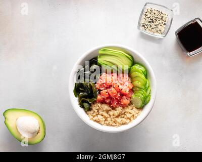 Cena sana buddha ciotola con quinoa, salmone, alghe wakame, avocado e cetriolo. Foto Stock