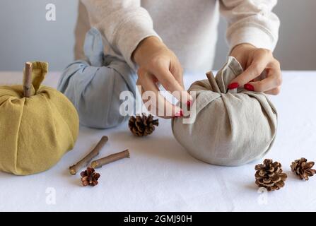 le mani femminili che fanno le zucche di tessuto Foto Stock