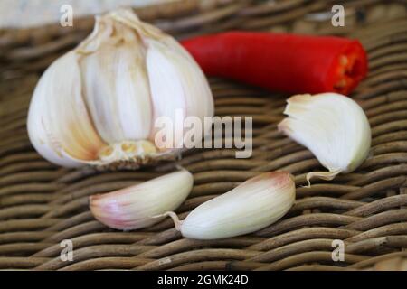 Spicchi di aglio fresco su vassoio di vimini, guardaroba Foto Stock