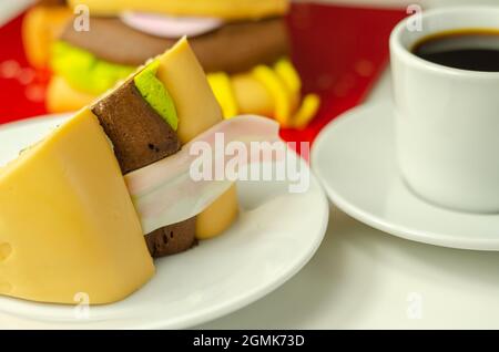 Pezzo della torta Burger, Madeira e torta stratificata di spugna di cioccolato, riempito con glassa ricoperta di glassa morbida e decorazioni di zucchero commestibile, torta i Foto Stock