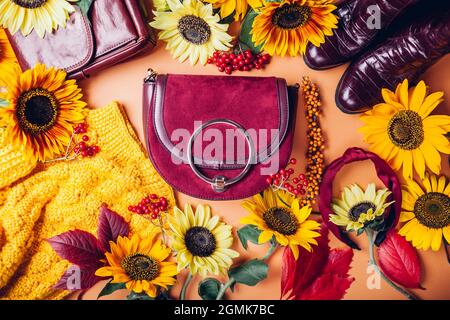 Vista dall'alto della moda femminile autunnale in colore rosso giallo arancio con fiori. Abbigliamento scarpe accessori. Concetto di vendita e shopping Foto Stock