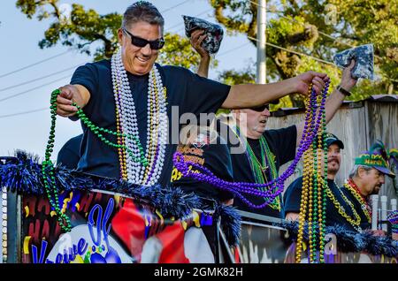 Un uomo lancia le perle del Mardi Gras durante la parata del Mardi Gras del giorno del Caino del Joe, 26 febbraio 2017, a Mobile, Alabama. Foto Stock