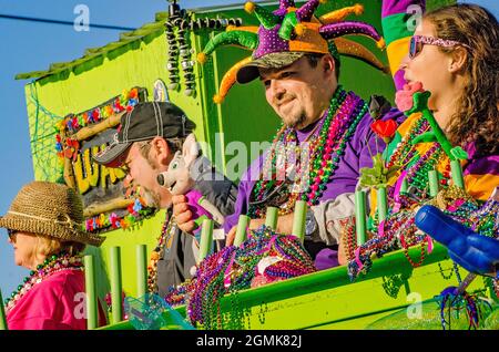 I Mardi Gras Revealers cavalcano un galleggiante durante la parata del Mardi Gras del giorno del Caino del Joe, 26 febbraio 2017, a Mobile, Alabama. Foto Stock