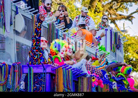 I Mardi Gras Revealers cavalcano un galleggiante del Mardi Gras durante la parata del Mardi Gras del giorno della Caina del Joe, 26 febbraio 2017, a Mobile, Alabama. Foto Stock