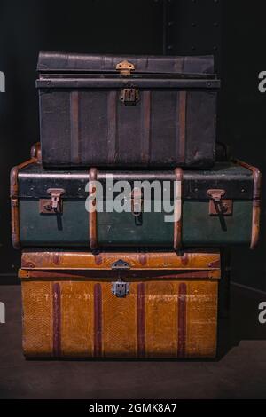 Fuoco selettivo su mucchio di tre valige vintage, vecchie e avvertono di viaggio o tronchi sul pavimento. Viaggio in stile retrò. Foto Stock