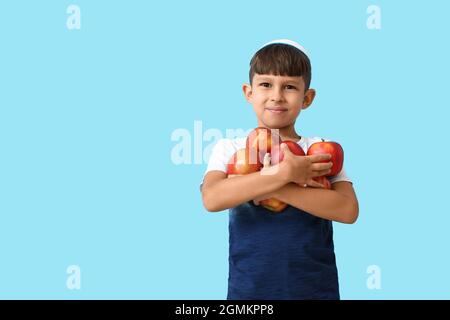 Ragazzo con mele e melograni su sfondo colorato. Rosh Hashanah (Capodanno ebraico) celebrazione Foto Stock