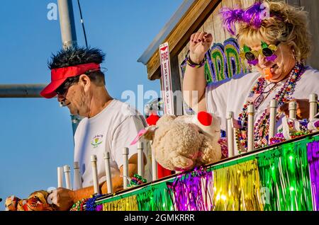 I Mardi Gras Revealers cavalcano un galleggiante durante la parata del Mardi Gras del giorno del Caino del Joe, 26 febbraio 2017, a Mobile, Alabama. Foto Stock