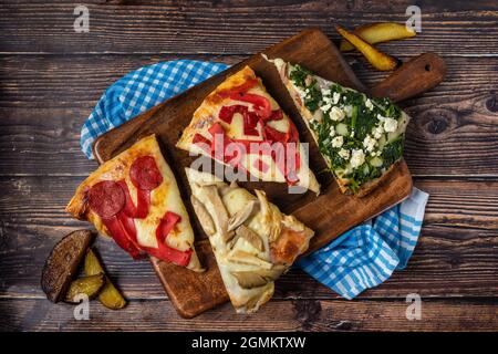 Pizza argentina assortita fatta a mano su sfondo di legno. Foto Stock