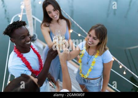 Gruppo multirazziale di giovani amici che festeggia il natale di nuovo anno su una barca Foto Stock