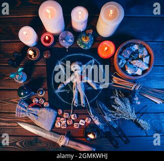 Bambola Voodoo sul tavolo in pentagramma e magici attributi, vista dall'alto. Foto Stock